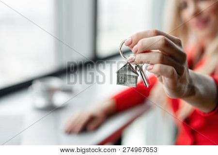 Mortgage Concept. Woman In Red Coral Business Suit Holding Key With House Shaped Keychain. Modern Li