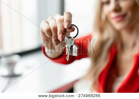 Mortgage Concept. Woman In Red Coral Business Suit Holding Key With House Shaped Keychain. Modern Li