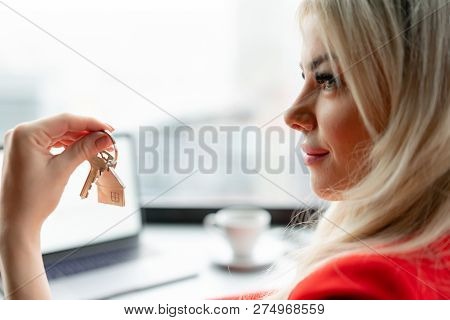 Mortgage Concept. Woman In Red Coral Business Suit Holding Key With House Shaped Keychain. Modern Li
