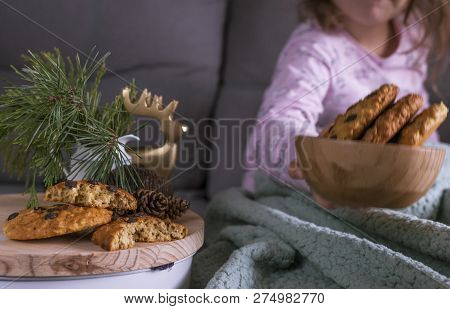 The Girl Has A Delicious Chocolate Biscuit Breakfast. A Child Is Sitting On A Dwan And Branches Of A