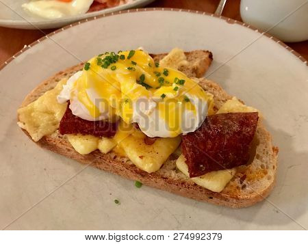 Egg Benedict With Turkish Sucuk And Gruyere Cheese. Organic Food.