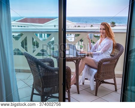 Woman Sitting On A Terrace And Holding A Cup.