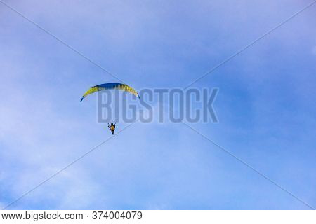 A Flying Paramotor On A Vibrant Sky With Cloud. Extreme Sport.