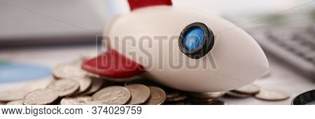 Rocket With Fell On A Pile Of Coins Close-up Background. World Financial Crisis Concept