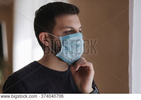 Man Put On Madical Mask At Home. Young Man In Protective Mask. Coronavirus Theme