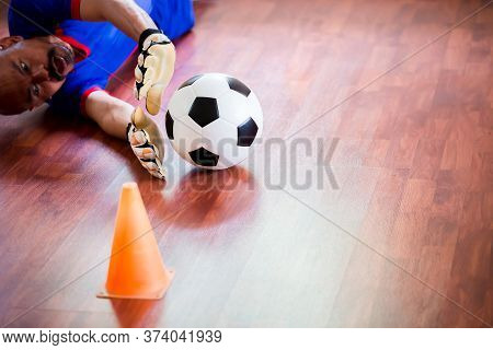 Ball In Hands Of Futsal Goalkeeper On Wooden Futsal Floor. Indoor Soccer Sports Hall.