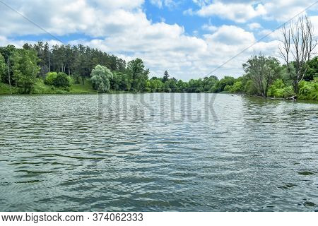Forest Lake Surrounded By Coniferous And Deciduous Trees On The Banks On A Sunny Spring-summer Day. 