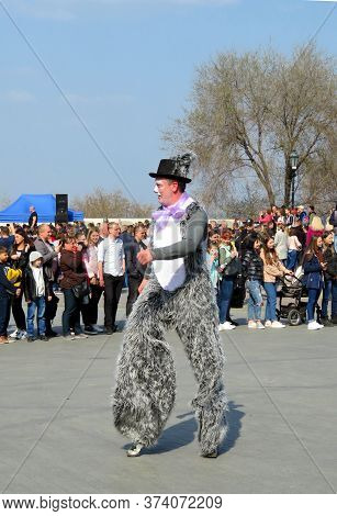 Odessa, Ukraine - 04 01 2019: Clown In A Suit Covered In Gray Fur Performs On Jumpers In Front Of A 