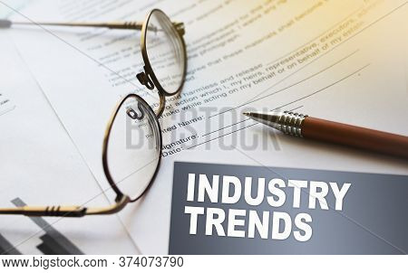 Iindustry Trends Text On A Card. Agreement With Pen And Glasses. Selective Focus. Business Work Offi