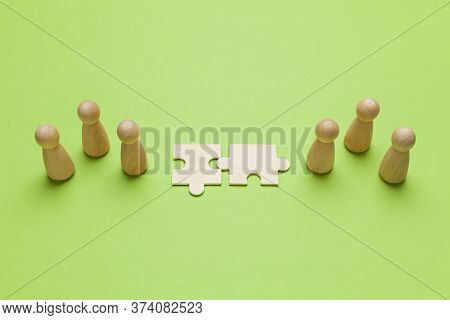 Wooden Figures With Pazzles On Green Background. Agreement Between Business Mans, Cooperation And De