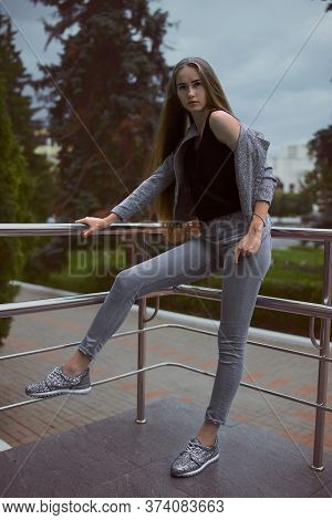 Girl In Grey Suit Posing Beside Grey Building
