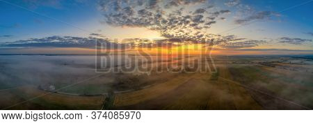 Beautiful Morning With Upraising Fog Over A Panoramic Field View At Sunrise Pure Nature.