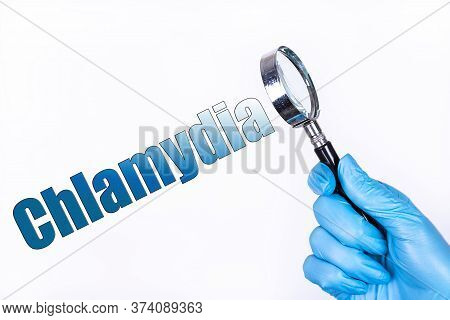 Chlamydia Text Written On The Background Of A Magnifying Glass In The Doctor Hand In A Medical Glove