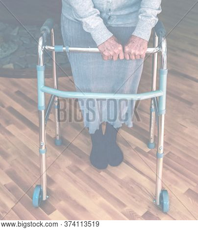 Old Wrinkled Hands On Walking Frame. Hands Of A Standing Senior Woman Leaning On A Rollator. Pension