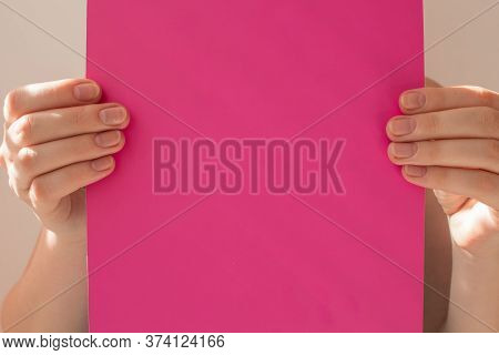 Hands Of Young Woman Holding Blank Purle Sheet Of Paper For Text And Design, Mock Up On Light Backgr