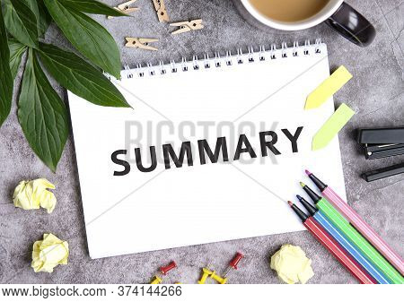 Summary On A Notebook With A Cup Of Coffee, Compressed Sheets, Crayons, Stapler