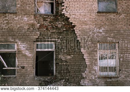 An Old Dilapidated Brick Building With A Hole In The Wall. The Concept Of Postapocalyptic, Abandonme