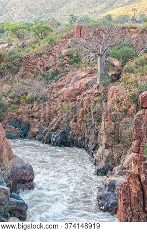 Part Of The Epupa Waterfalls In The Kunene River At Sunset. A Baobab Tree Is Visible
