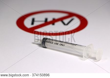 A Syringe On White Floor With Out Focus Symbolic Of Anti Hiv.