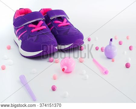 Close Up View Of Violet Pink Childrens Sneakers With Pink And White Balls And Felt-tip Pens At Peach