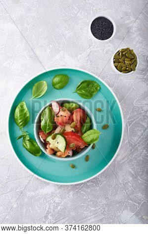 Summer Salad Of Fresh With Basil Vegetables Served In A Bowl. A Tomato. Cucumbers, Onions, Radishes.