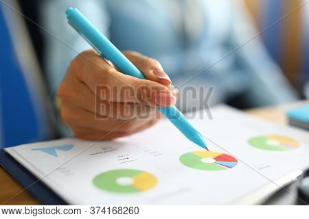 Close-up Of Businesslady Hand Holding Pen. Finance Manager Analysing Bar Charts And Graphs. Woman Wr