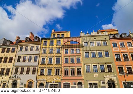 Typical colorful houses buildings with multicolored facade, outdoor porch with front steps stairs, Piwna street with cobblestone road, blue sky background, old historical city centre, Gdansk, Poland