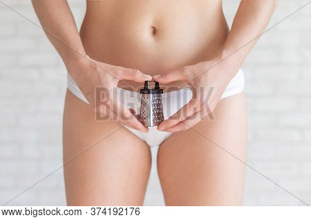 Unrecognizable Woman In White Panties Holds In Hands A Mini Grater. Metaphor Of The Bristles After D