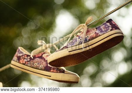 Sneakers After Washing Are Dried On A Rope In A Summer Garden.