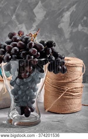 Bunches Of Fresh Ripe Red Grapes On A Concrete Textural Surface. Branch Of Pink Grapes. Red Wine Gra