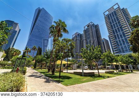 Tall modern business and residential buildings under blue sky as seen from Sarona market in Tel Aviv, Israel (low angle view).