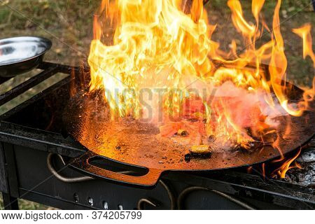 Burning Food In A Camping Cast Iron Saj. Flame Cover A Metal Dish On The Grill With Braised Liver An