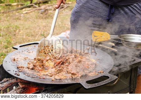 Cooking In A Camping Cast Iron Saj. Metal Dish On The Hot Grill With Braised Liver And Vegetable Roa