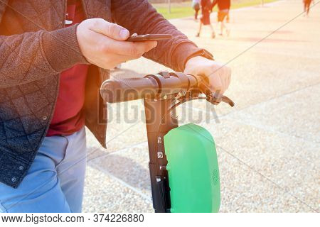 Close Up Image Of A Man On An Electric Scooter Paying Online. Smart City
