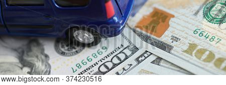 Blue Toy Minivan Car Costs On Scattered Dollars. Renewal Vehicle. Contractual Financial Liability. S