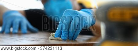 Carpenter In Gloves Cleans Polishes Wooden Surface. Joiner Polish Wooden Surface Canvas On Table. Pr