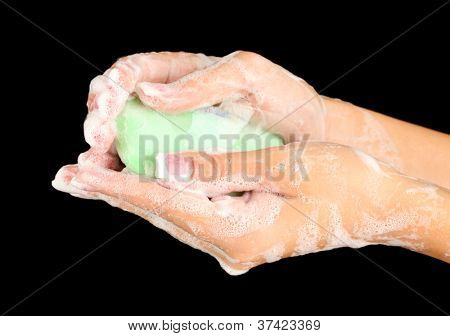 ผู้หญิงมือใน soapsuds บนพื้นหลังสีดำอย่างใกล้ชิด