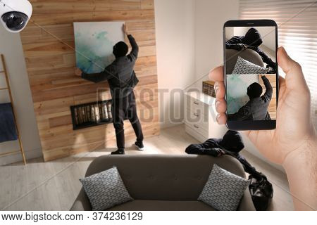 Man Monitoring Situation At His House With Cctv App On Smartphone, Closeup. Thieves Stealing Picture