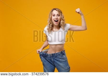 Shocked Woman In White T-shirt Isolated On Orange Background. Proper Nutrition Losing Weight Healthy