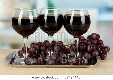 Vino rosso in vetro su salver sullo sfondo della camera