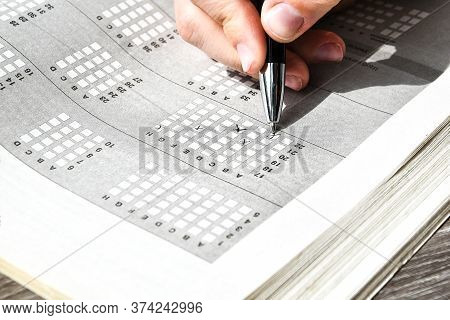 Student Hand With Pencil For The Exam. Printed School Test, Home Education, Study At Home