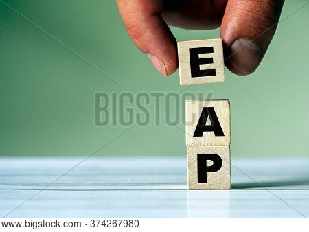 The Hand Puts The Cube Block With The Inscription Eap. Eap Symbol.