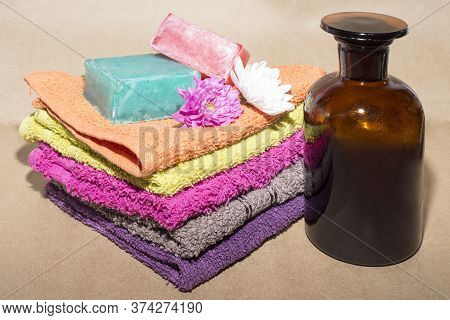 Soap Bar On Top Of Facecloths Off Various Shades With Flowers And Bottle