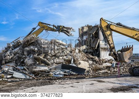 Building House Demolition Site Excavator With Hydraulic Crasher Machine And Yellow Container
