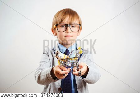 Cute Boy With Shopping Cart Isolated On White. Online Shop. Little Kid Holding Shopping Trolley With