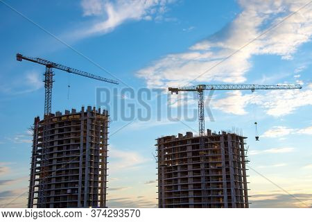 Preparing To Pour A Bucket Of Concrete Into Formwork.tower Crane Lifting Cement Bucket During Constr