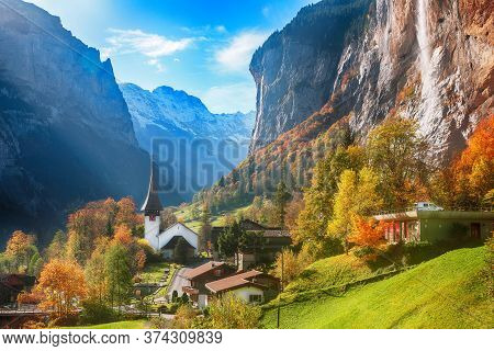 Amazing Autumn Landscape Of Touristic Alpine Village Lauterbrunnen With Famous Church And Staubbach 