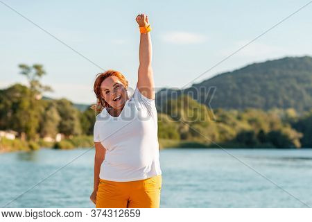 Expressions And Emotions. Portrait Of Happy Overweight Woman Raised Her Hand In Joy. In The Backgrou