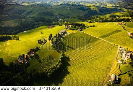 Aerial View Of Green Hills And Vineyards With Mountains In Background. Austria Vineyards Landscape. 