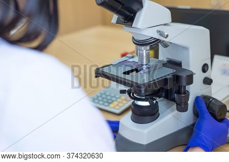 Laboratory Assistant Is Looking Through A Microscope. Close-up Doctor Laboratory Assistant Looking T